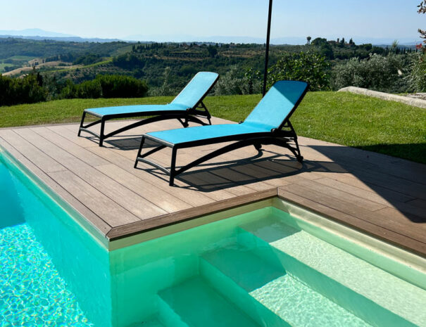 Villa Bellavista swimming pool; deck with lounge chair and umbrella in sunny day - villa rentals by Timeless Tuscany tour operator